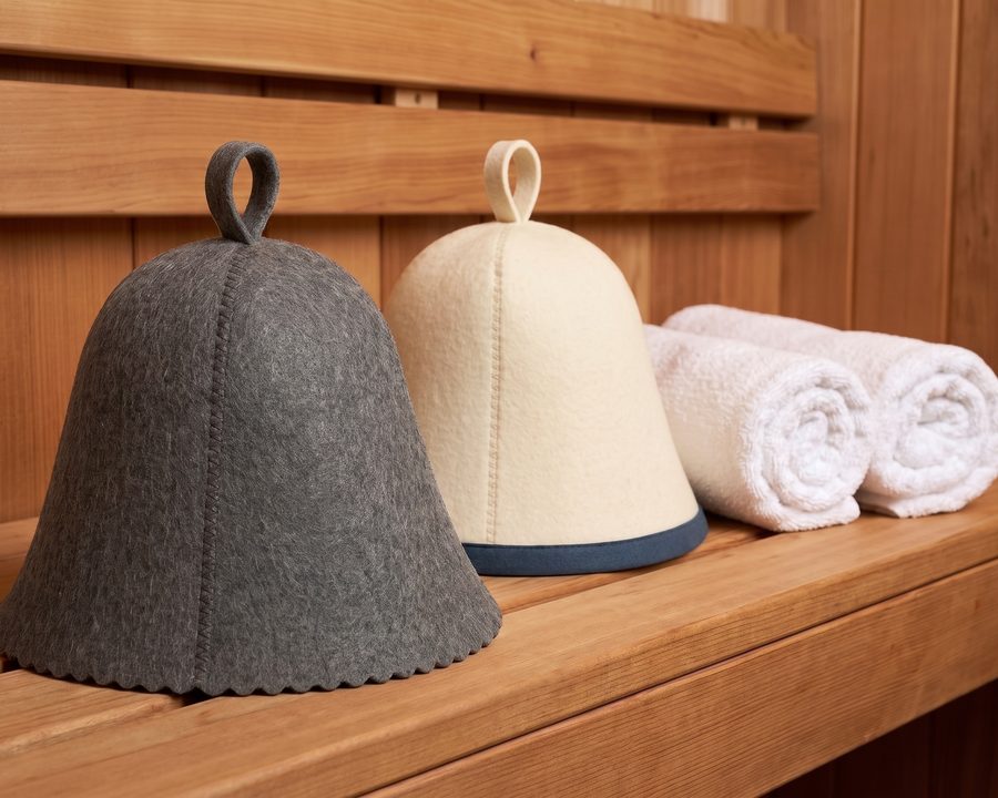 DIVELUX grey and white wool sauna hats on a sauna bench